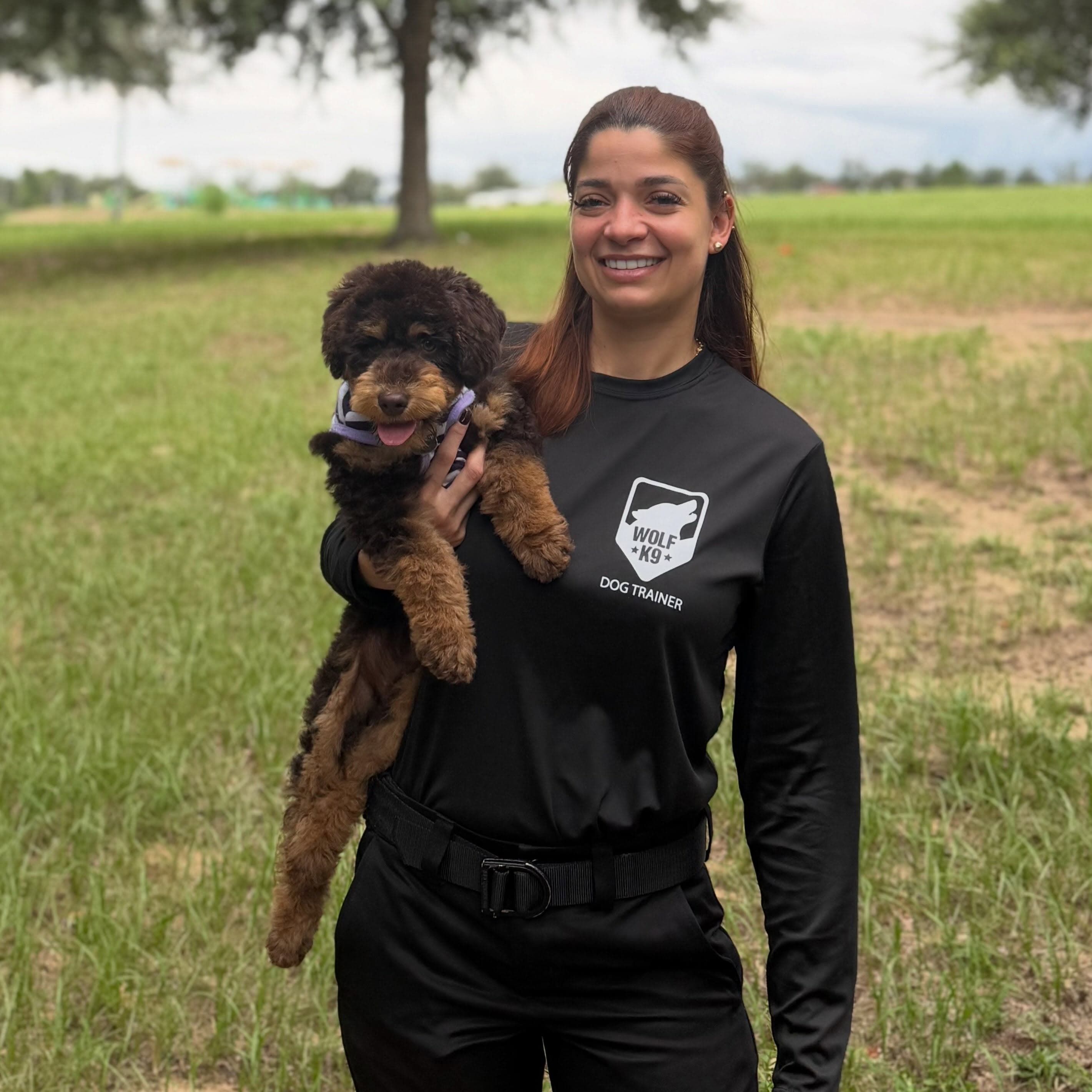 Johanna, Wolf K9 Training dog trainer, holding a poodle puppy in Central Florida
